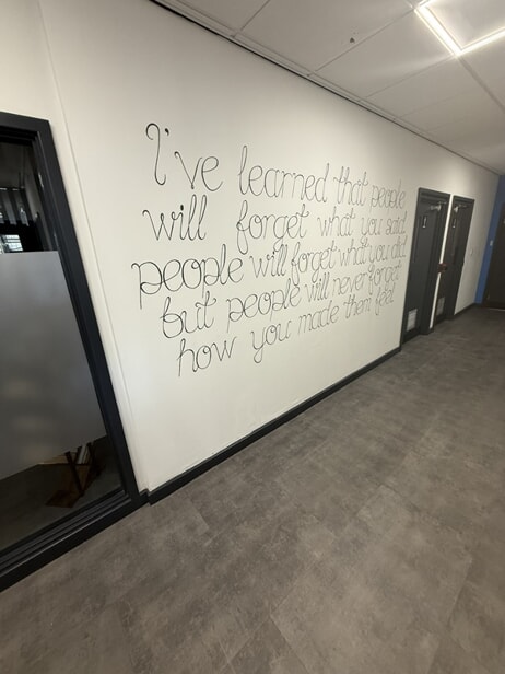 Phase 2 before new acrylic panel timeline. Fret-cut wall vinyl quote graphic currently installed.